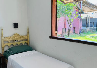Foto de um dos nossos quartos com cama de solteiro e vista para o jardim